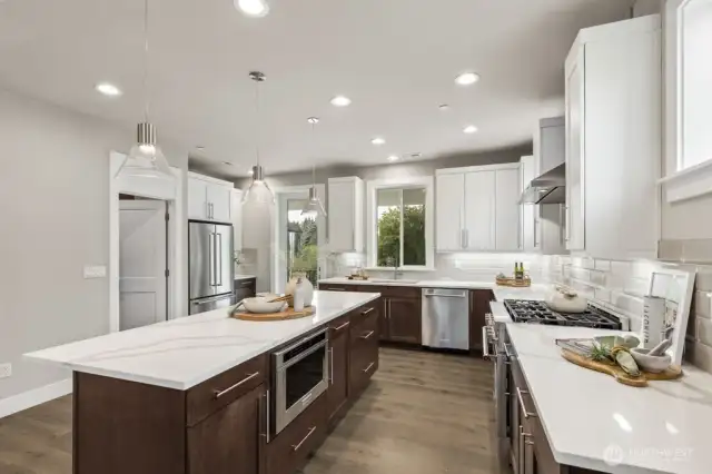 Lots of room to serve your favorite meals on the island. Walk in pantry next to refrigerator and deck door in the background.