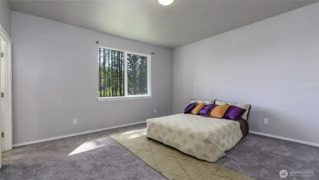 Space primary bedroom with a walk in closet and attached bathroom.