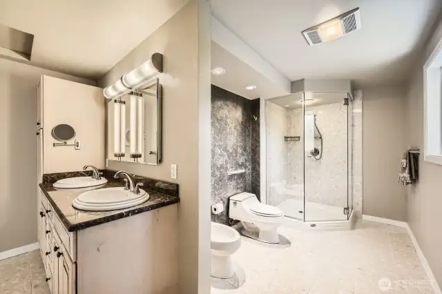 The luxurious primary bathroom features separate areas, a walk-in shower, bidet, and marble terrazzo tile flooring.