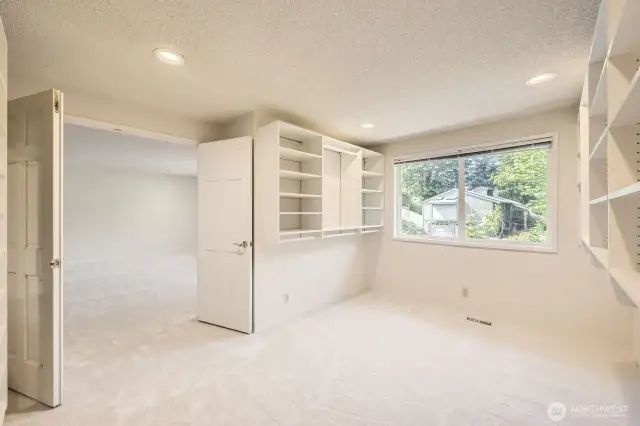 The Primary Suite’s walk-in closet is as large as a normal bedroom and it has many built-in shelves, a large window and a double-door entry.