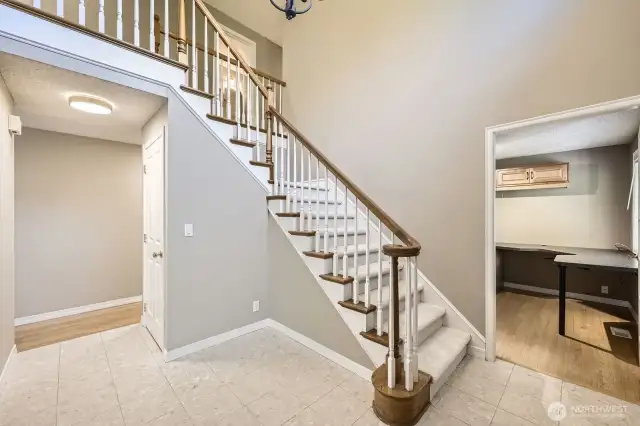 The grand entry will welcome your guests with its two-story ceiling, curved banister and marble terrazzo tile floors.