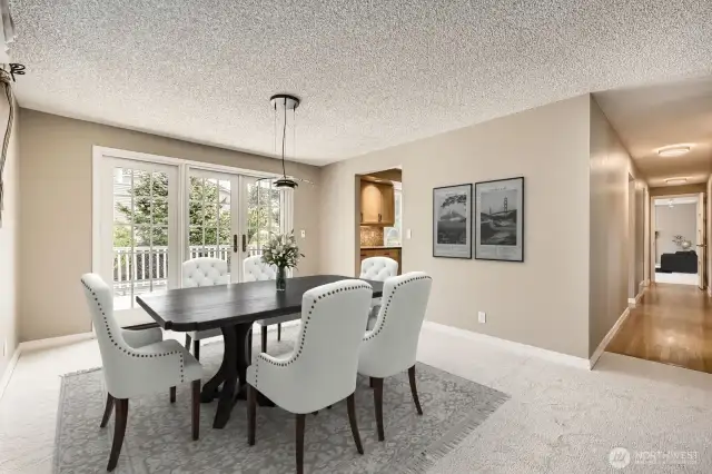 The spacious dining room views the lush backyard and deck through the newer Marvin French doors.