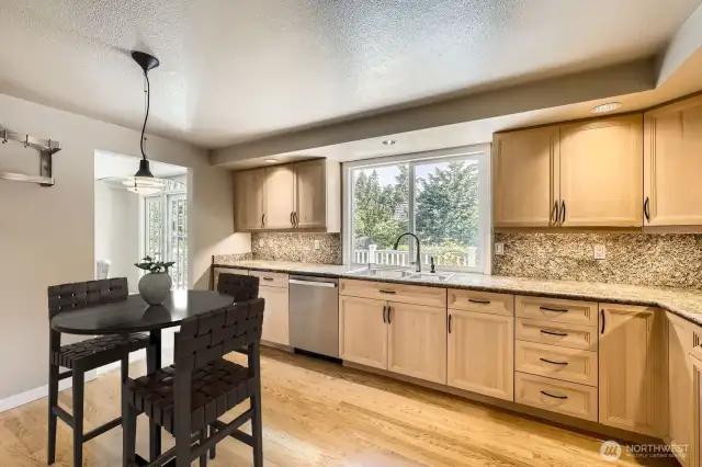 The large kitchen boasts granite countertops and backsplash, newer appliances and hardwood floors.  The window over the sink views the private backyard, deck and pool.