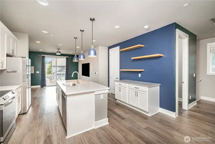 Kitchen also features versatile space with floating shelves—ideal for a coffee bar, stylish display, or home organization hub.