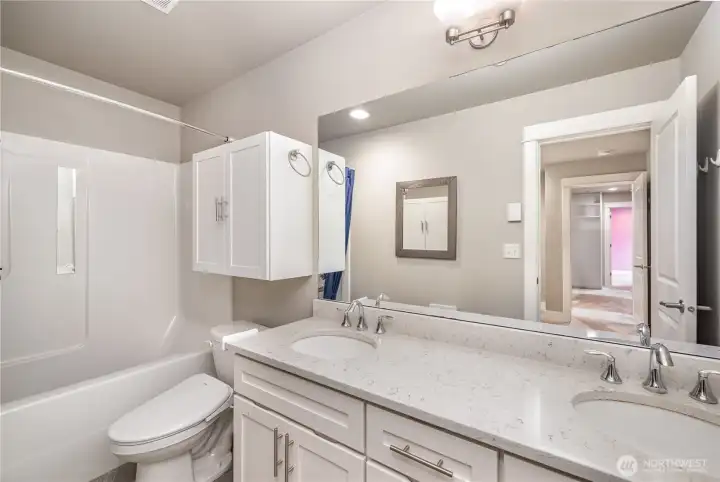 Primary en-suite features dual sinks with quartz countertops, ample storage, and a dedicated outlet for bidets or smart toilet seats—combining comfort with modern convenience.