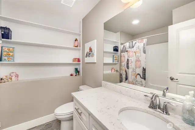 Downstairs full bathroom also boasts built-in shelving, quartz countertops, and a dedicated outlet for smart toilets or bidets.