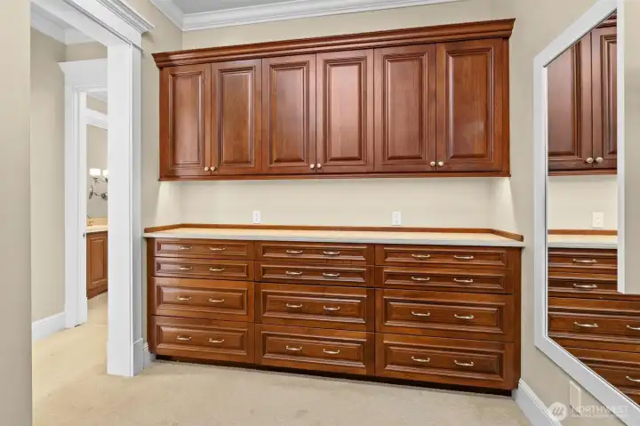 Large walk-in closet has this custom built 8' dresser and overhead cabinets.