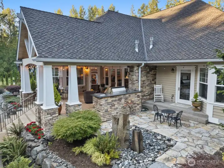 This angle shows the private patio with water feature and sitting area off of the primary suite.  Real wood Cedar siding.