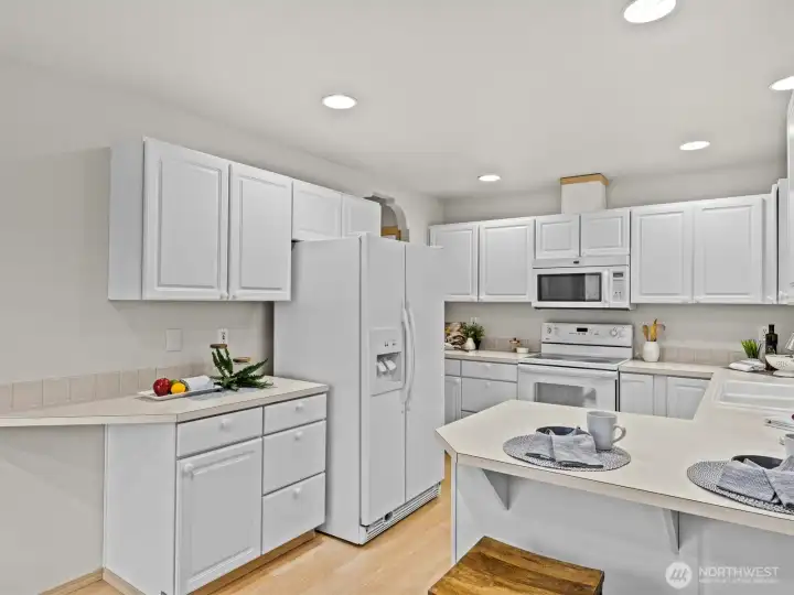 The spacious kitchen is flooded with natural light from the windows and sliding glass door to the upper deck.