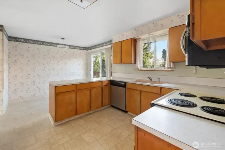 Kitchen open to eating area with sliding door to back deck
