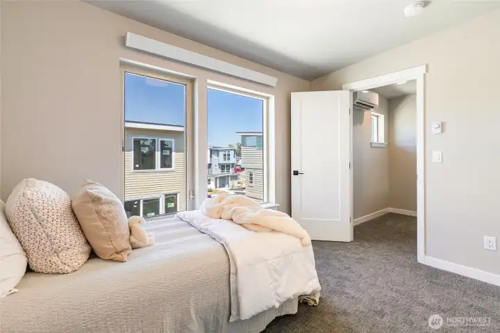 Staged photo of like unit. 2nd bedroom with large windows create a bright and sunny bedroom