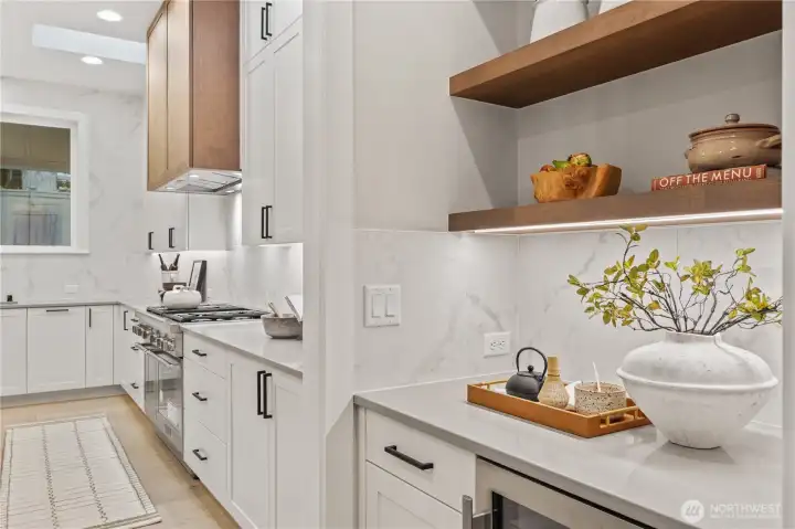 Wine/beverage cooler and open shelving opposite the walk-in pantry