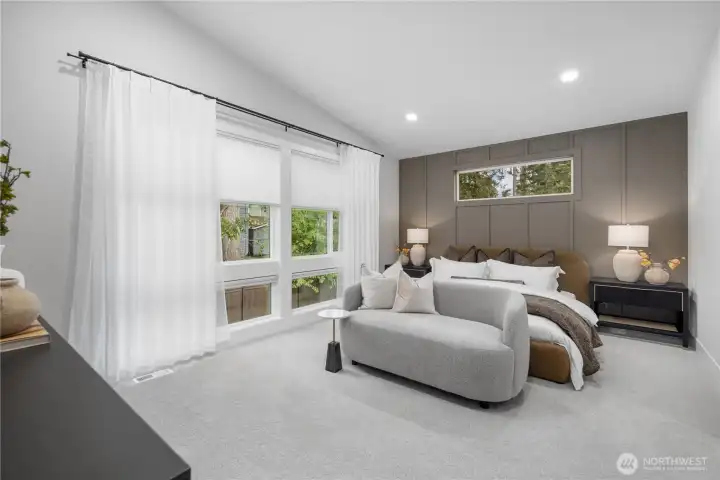 Luxurious primary bedroom with a wall of windows and beautiful accent wall