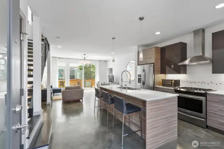 Open and airy main level features high ceilings, sleek concrete heated flooring, modern design, bright interiors, ample windows, and oversized glass doors that fill the space with natural light. Open and airy main level features high ceilings, sleek concrete heated flooring, modern design, bright interiors, ample windows, and oversized glass doors that fill the space with natural light.