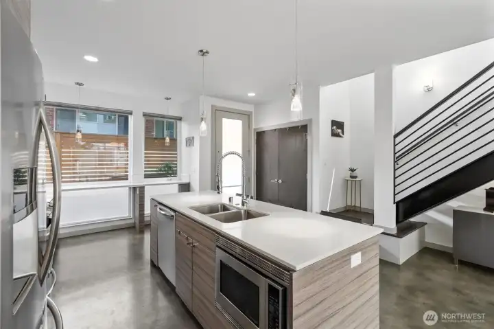 Open and airy main level features high ceilings, sleek concrete heated flooring, modern design, bright interiors, ample windows, and oversized glass doors that fill the space with natural light. Open and airy main level features high ceilings, sleek concrete heated flooring, modern design, bright interiors, ample windows, and oversized glass doors that fill the space with natural light.