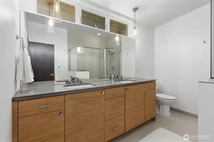 Primary bathroom featuring a double vanity, heated floors, an oversized shower, and thoughtful finishes throughout. Primary bathroom featuring a double vanity, heated floors, an oversized shower, and thoughtful finishes throughout.