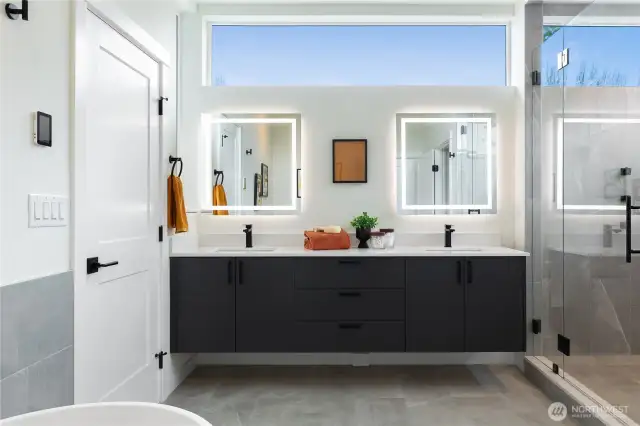 Primary en-suite bathroom with dual sinks, back it vanity mirrors, storage and great natural light.