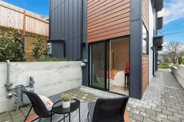 Private patio and green space off of one of the main level bedrooms.