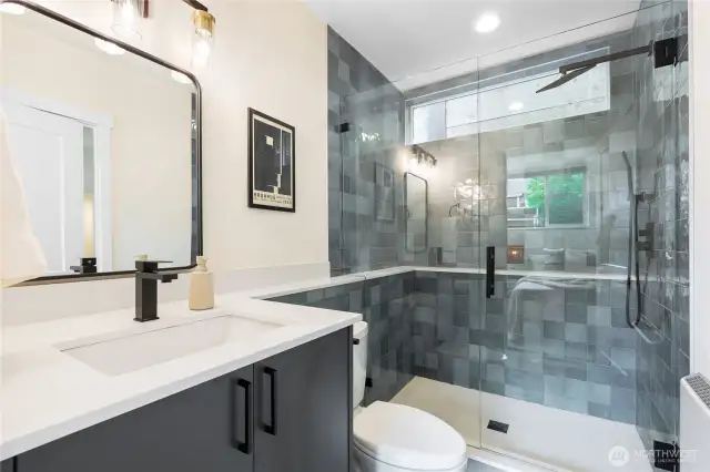 Large first floor three quarter bathroom with oversized tile shower, quartz counters and high end fixtures and finishes.