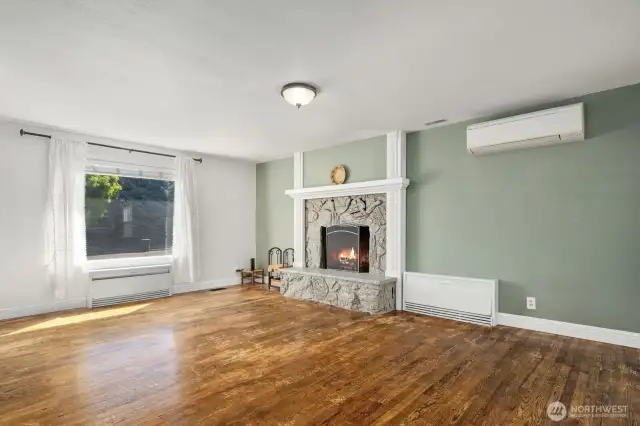 Large living room offers gleaming oak hardwood floors with a raised hearth fireplace with mantle.