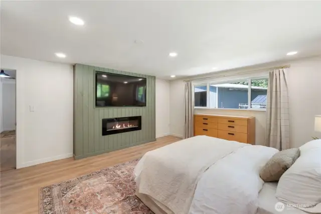 Another view of the primary bedroom with built-in electric fireplace.