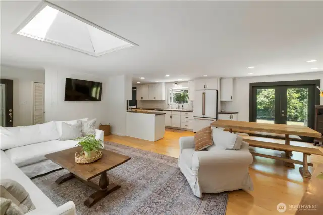 The open floor plan features a family room with beautiful hardwood floors and a large skylight.