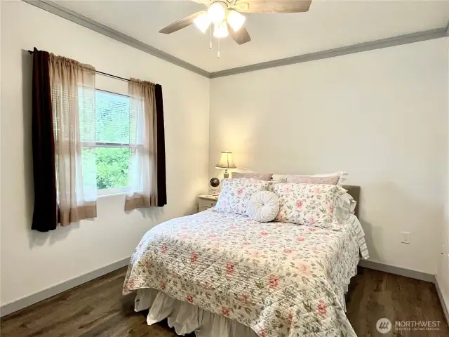 Spacious Primary Suite with large window, ceiling fan.