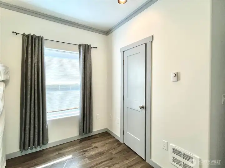 Front Bedroom and view of the window   facing streetside. Comfotable ceiling fan and   wall heater to keep you cozy