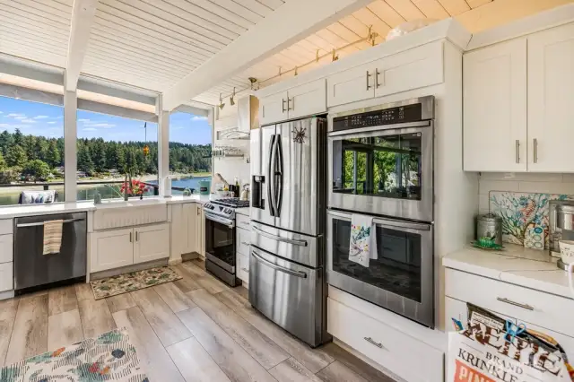 A kitchen truly designed for entertaining with 3 ovens, a microwave, and a large porcelain farm sink
