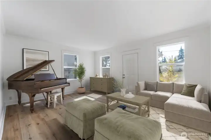 Step into a sun-lit gathering space that reflects the home’s century-old charm. The tall windows and brand new wood floors set the stage for both everyday living and special moments. There’s room here for music, conversation, and the sense of connection that has defined this property since it first anchored the neighborhood in 1910. (Virtually staged)