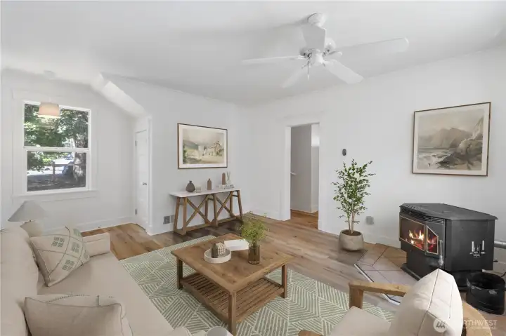 A cozy retreat anchored by a pellet stove, this room provides warmth and ambiance throughout the seasons. The clean lines of the 1910 architecture blend effortlessly with updated finishes, creating a timeless space for reading, relaxing, or enjoying quiet evenings by the fire. Newly painted .(Virtually Staged)