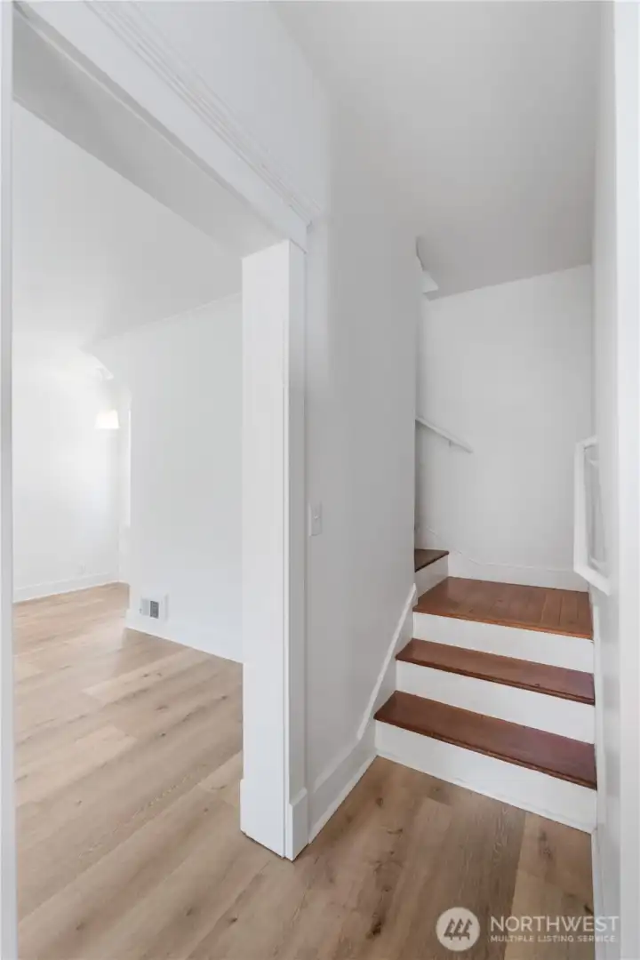 The staircase serves as a reminder of the home’s 1910 roots, blending warm wood steps with crisp white trim. This transitional space connects the main living areas with the private upstairs retreat, balancing old-world craftsmanship with modern updates.