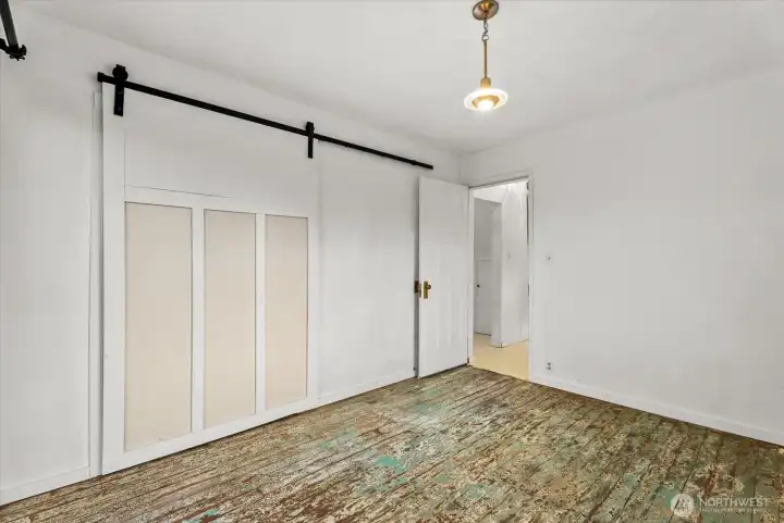 Main-floor bedroom refreshed with a new closet, barn door, and custom lighting.