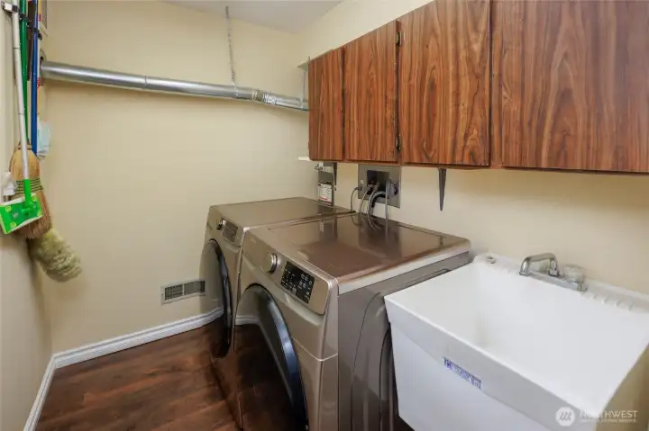 Laundry room w/ upper storage cabinets & utility sink.