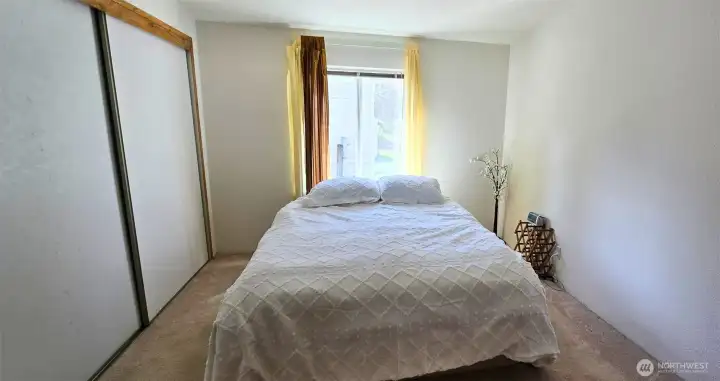 Primary bedroom with natural light and closet storage, offering a comfortable retreat