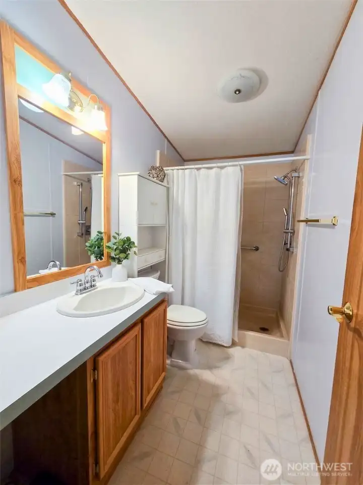 Second bathroom with extended vanity and walk-in shower layout for ease of use