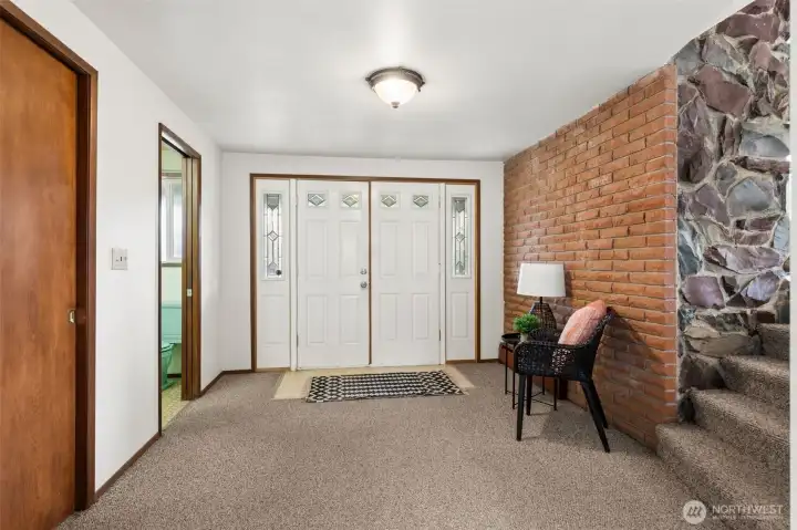 The entry invites you into the main floor with a powder room (half bath) and coat closet on the left, carpet on the floor here. The main floor also includes a family room, laundry, 2 office or hobby rooms and the garage entry. On the right the steps lead to the living room a half level up (split level), kitchen & dining room on the same level as living room.