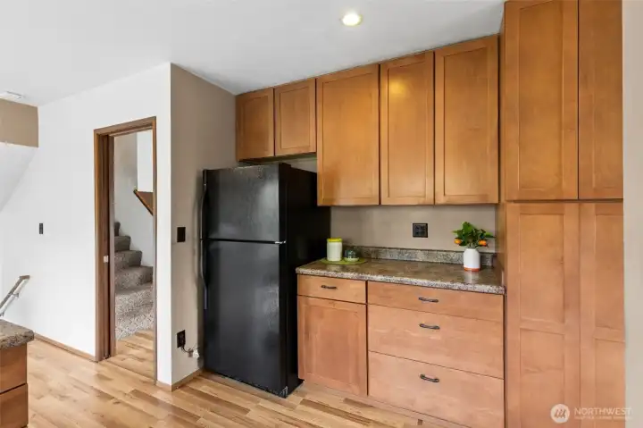 Showing the kitchen and featuring some of the ample storage. Laminate floors. The stairs in center lead to the 4 bedrooms. Handrail on the left are where the steps that lead to the family room on the lower split level.