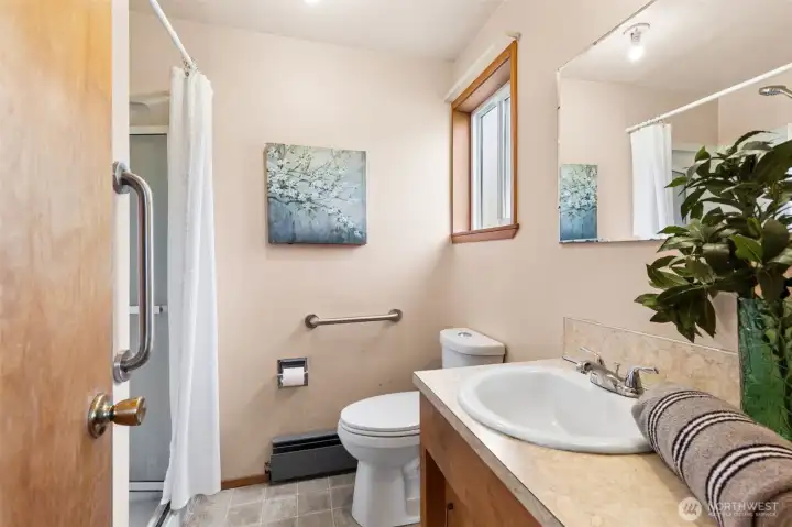 The ensuite bathroom for primary with shower & linen closet. Vinyl flooring.