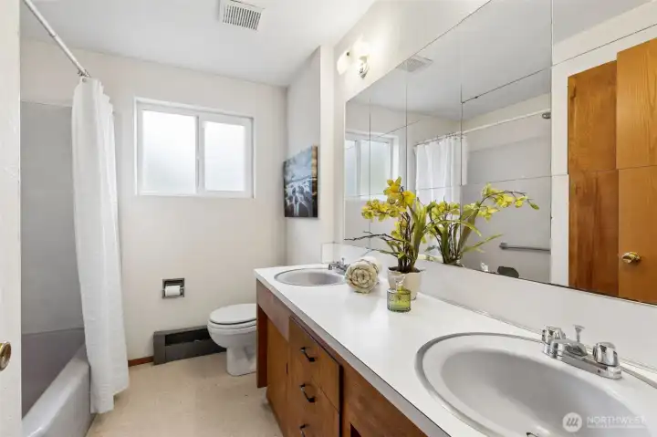 This full bathroom with tub/shower combo, two sink vanity. Built-in cabinets for linen & toiletries. Linoleum flooring. Located on 2nd floor near the bedrooms.