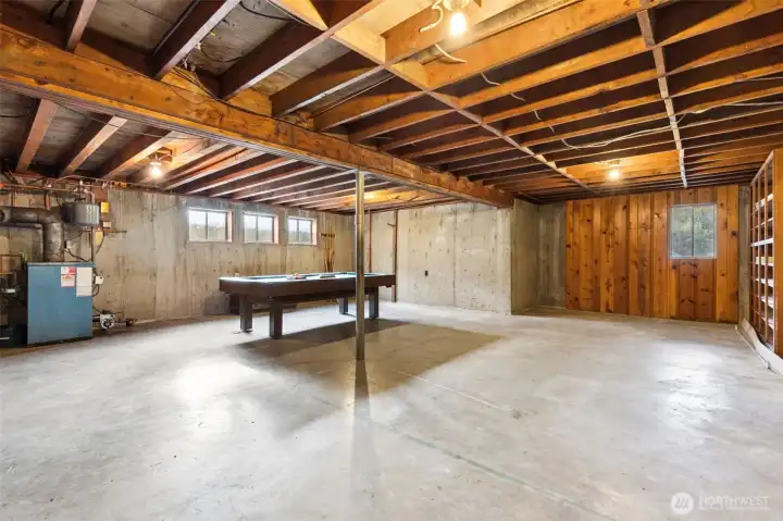 As is, the basement offers additional space for playing, hobbies, storage...you name it! Bring a freezer and there are built-in shelves for extra pantry storage. Pool table is included! The oil furnace, water heater are down here too! Perhaps finish this space and add a kitchenette, bathroom and a door where the paneled wall is...so many options!