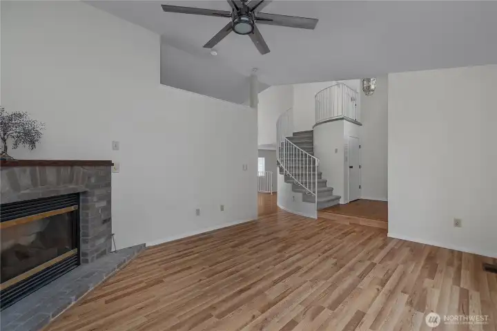 Spacious main living area with fireplace, vaulted ceiling, and open sightlines to the entry.