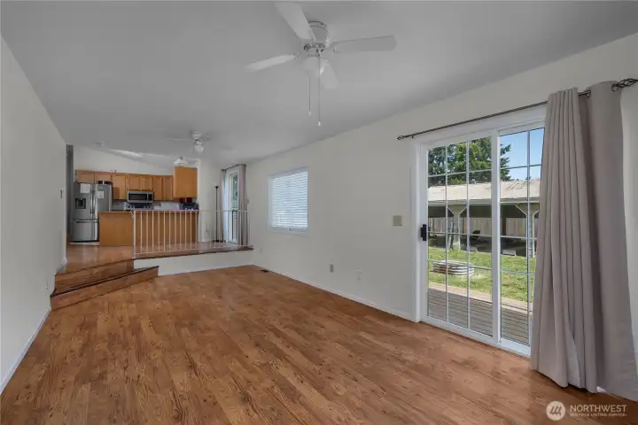 Open family room with kitchen connection, sliding door, and abundant natural light.
