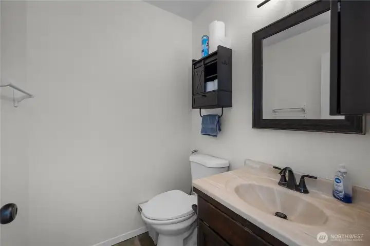 Main-level half bath with vanity, black fixtures, and simple updated styling.