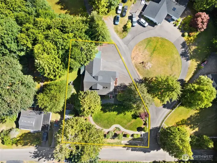 Nestled back from the street and enveloped by a thick border of mature trees, the home features ample parking space, and a beautifully curved front lawn that maximizes the property's serene, park-like setting.
