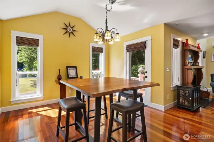 Enjoy casual meals or formal dinner parties in this bright, vaulted dining area. Bathed in natural light from multiple windows and a glass panel door, the space offers effortless transition to the outdoor deck for seamless indoor/outdoor hosting.