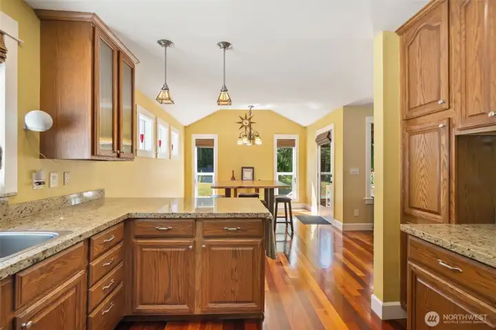 This perspective captures the wonderful open-concept layout, looking directly from the kitchen workstation into the bright, vaulted dining space.