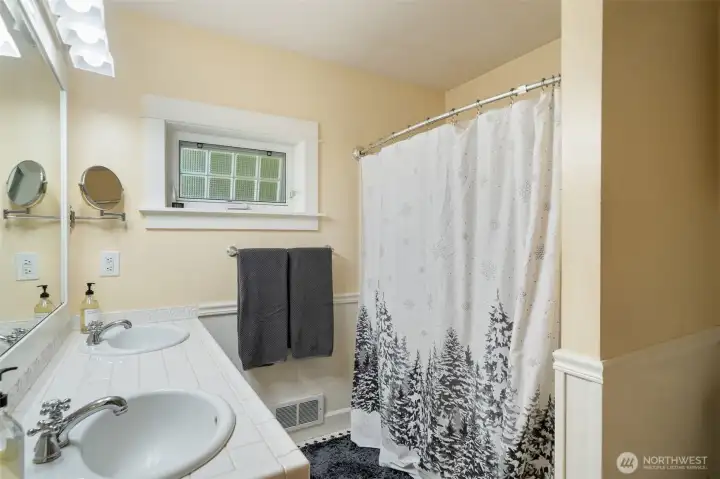 A private shower/tub combination and a high-set privacy block window complete this clean and inviting space.