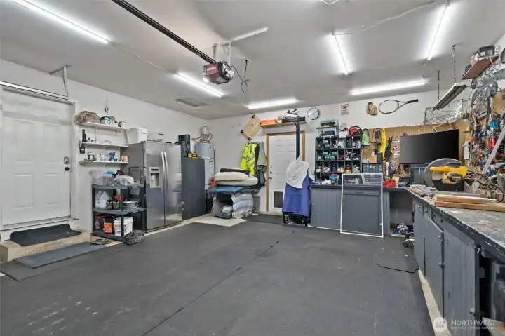 Another angle of the expansive garage highlights its exceptional storage versatility. With plenty of room left over for vehicle parking, this side features dedicated space for a secondary refrigerator, built-in shelving nooks, pet accommodations