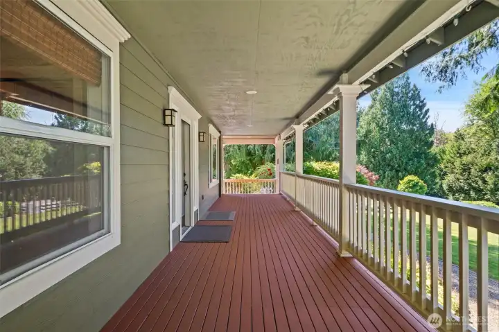 Enjoy peaceful, year-round outdoor living on this massive covered porch. Featuring newly stained decking, a pristine white railing system, and classic columns, it wraps along the side of the home to offer a shaded, private vantage point over the lush lawns and garden paths.